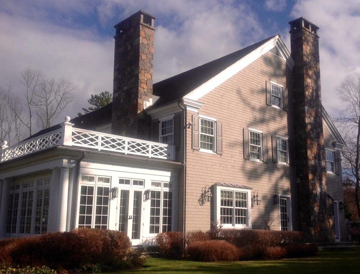 Shingle-style Westchester home exterior with restored stone chimneys and painted trim